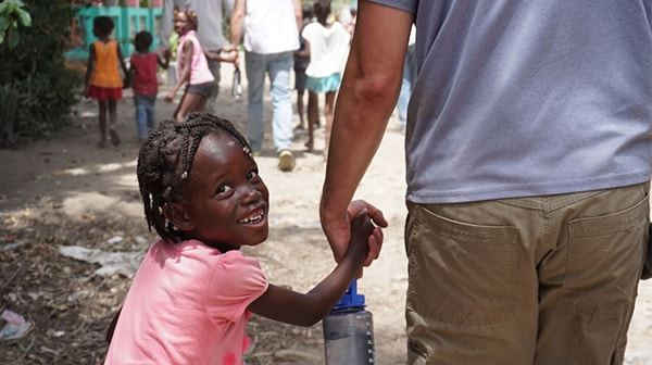 child holding hands with missionary