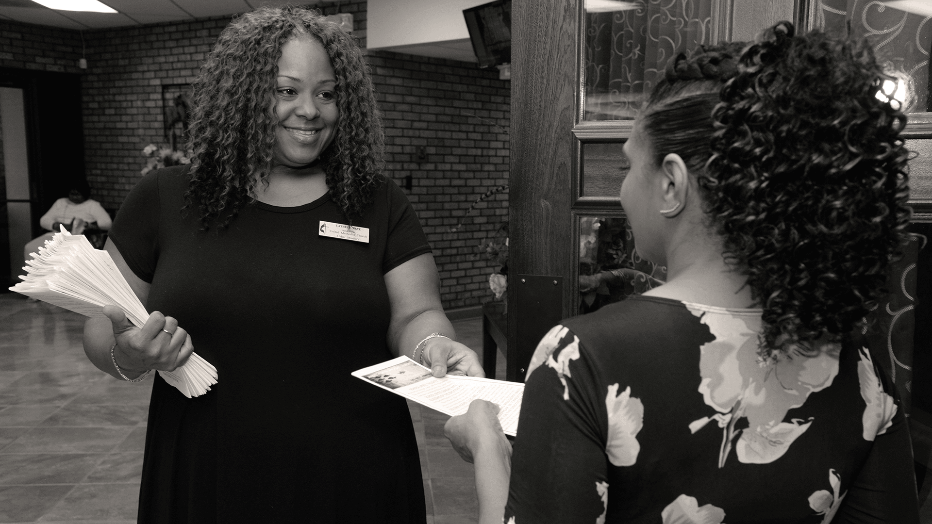 The #BeUMC campaign reminds us of who we are at our best. As people of God called The United Methodist Church, we’re faithful followers of Jesus seeking to make the world a better place. Welcoming/Greet (Design asset, background image of woman greeting worship attendee).